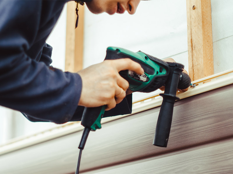 Premier gutter solutions team performing vinyl siding repair in Salt Lake City