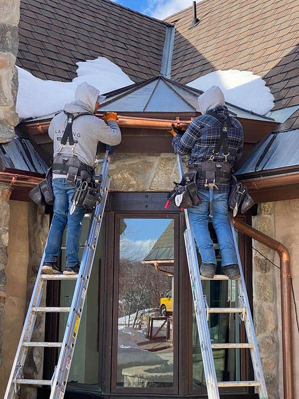 Workers installing copper gutters on a home in Salt Lake City, Utah