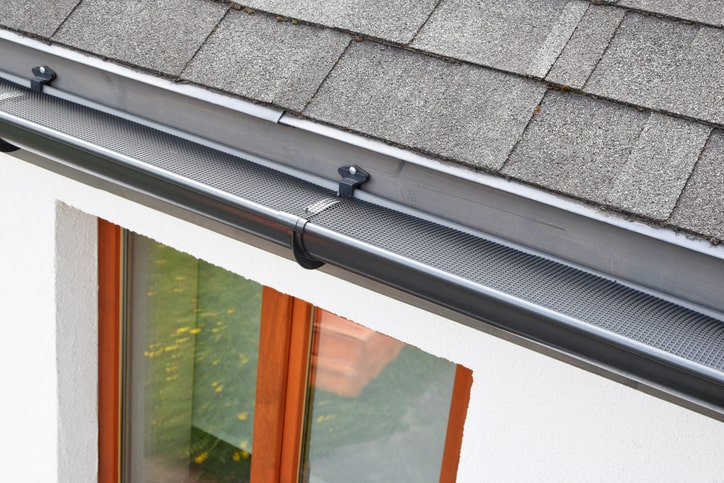 Rain gutter with leaf guard installed to block leaves from entering the gutter in Salt Lake City