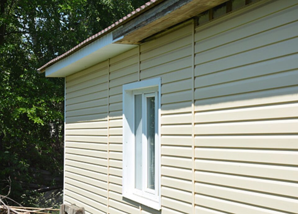 Expert siding repair on a home in Salt Lake City, Utah, with beige siding and white trim